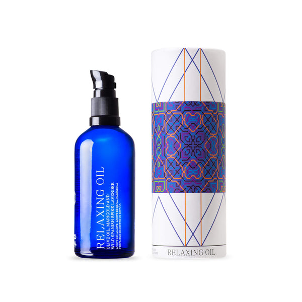 ANDALUZ Skincare Relaxing Oil made with hand-cultivated olive oil and wild spanish spike lavender. It comes in a bright blue glass bottle with a black plastic pump and a cylindrical box with colorful spanish designs inspired from the tiles at the alhambra palace in granada spain